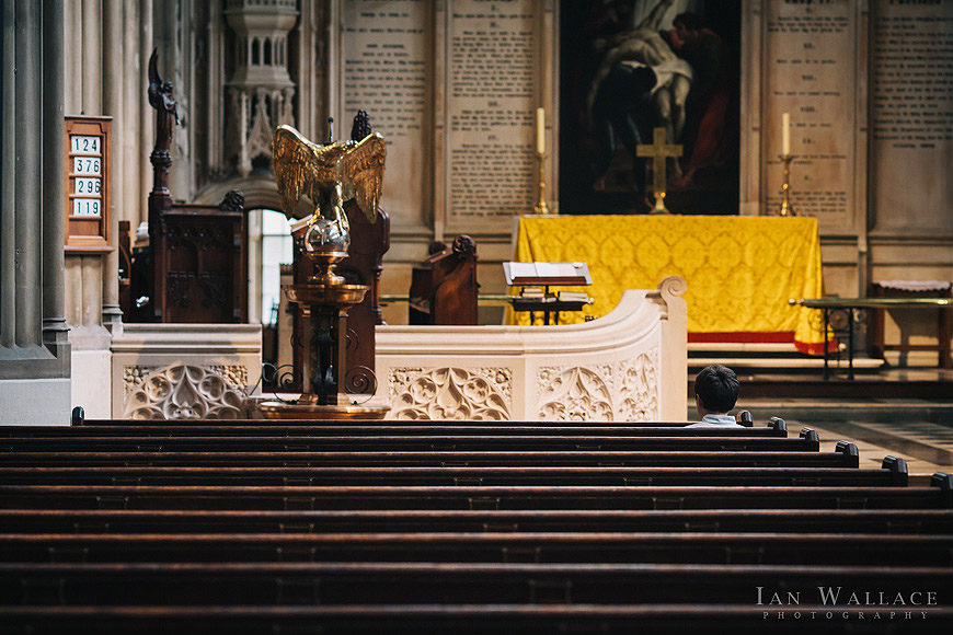 Solitary boy sat in the pews at St Luke's church, waiting for the ceremony