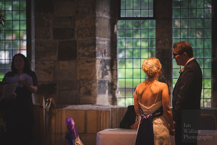 Bride and groom listening to choir at the Hospitium in York during their wedding ceremony