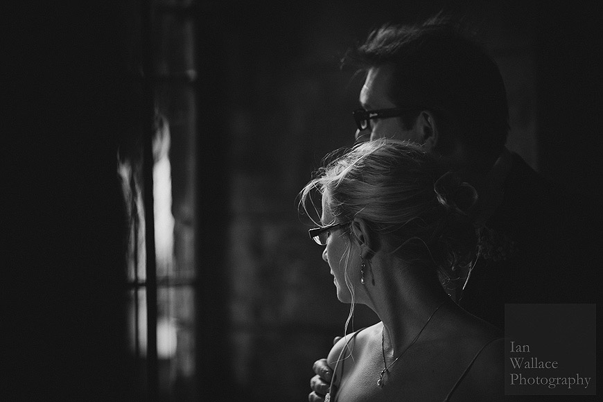 Moody side lit black and white portrait of bride and groom