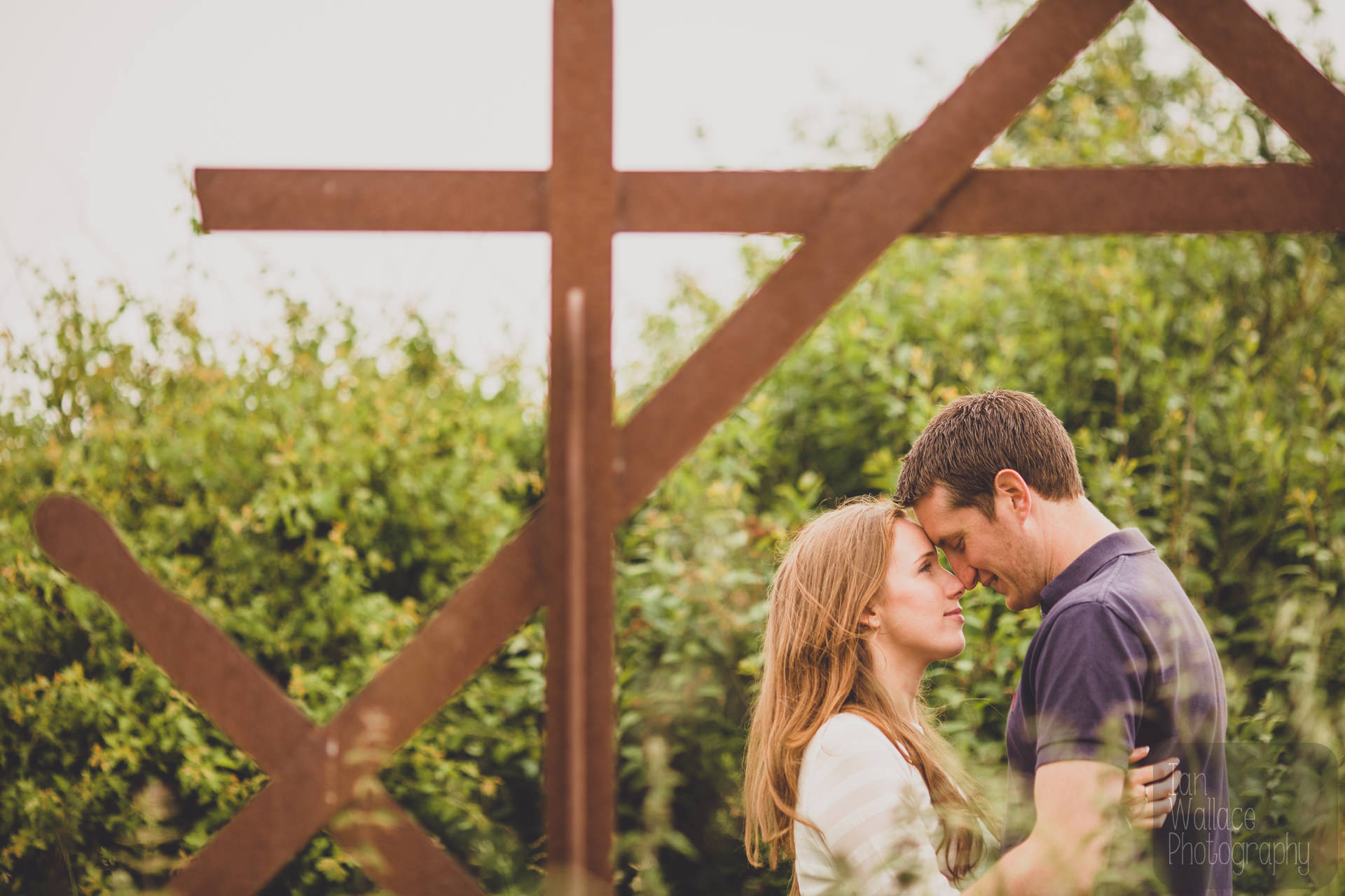 A posing couple next to an artwork during an engagement shoot in Flamborough