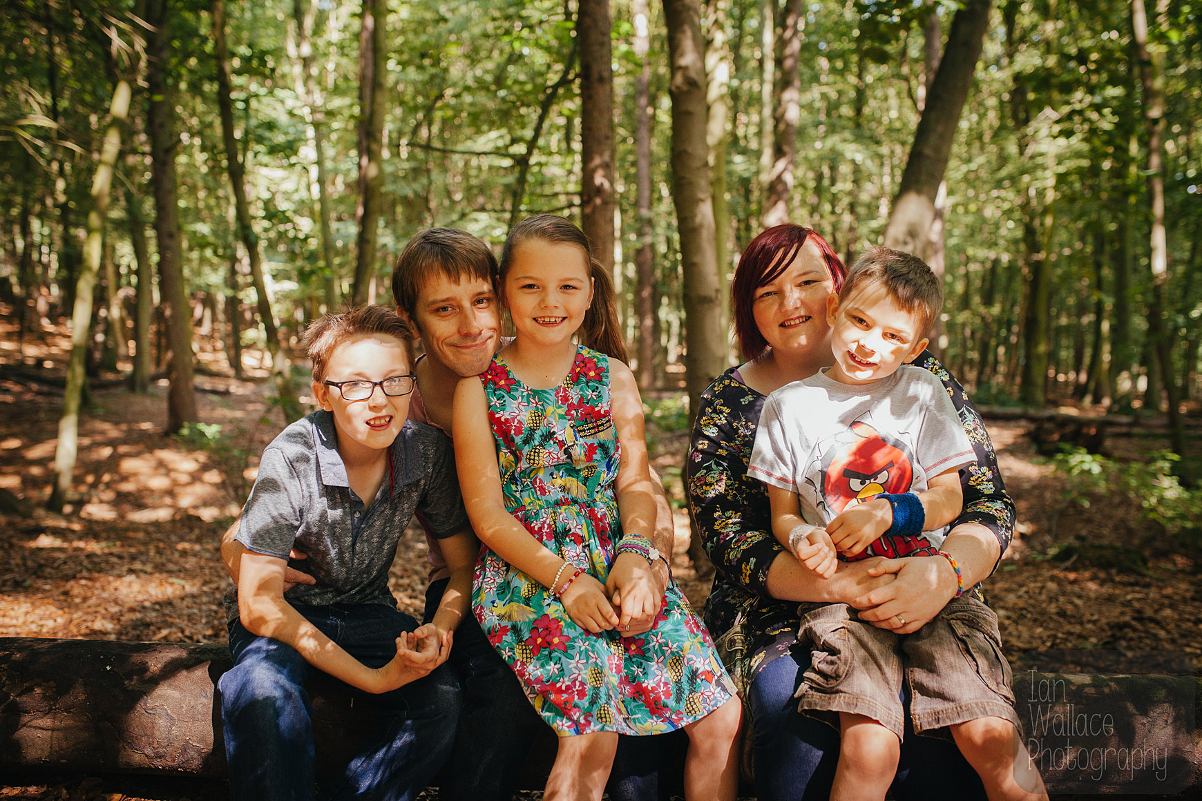 Family portrait taken in beautiful bespeckled light in the woodland at Newmiller Dam