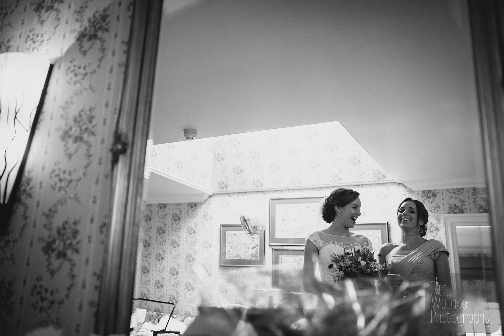 Bride and bridesmaid share a moment, laughing during the final build up