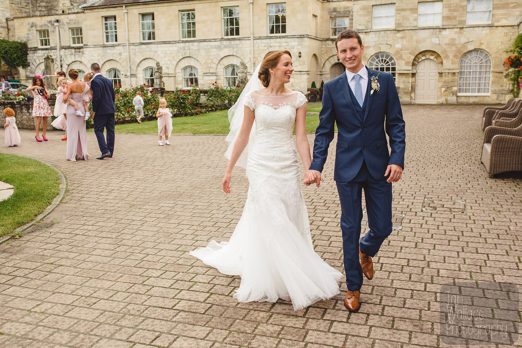 Happy couple leave the wedding party for some portraits