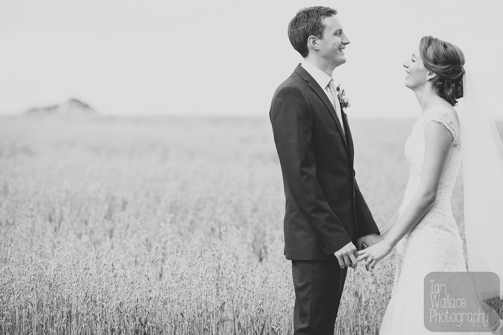Reportage fine art photo of couple laughing away from wedding party.