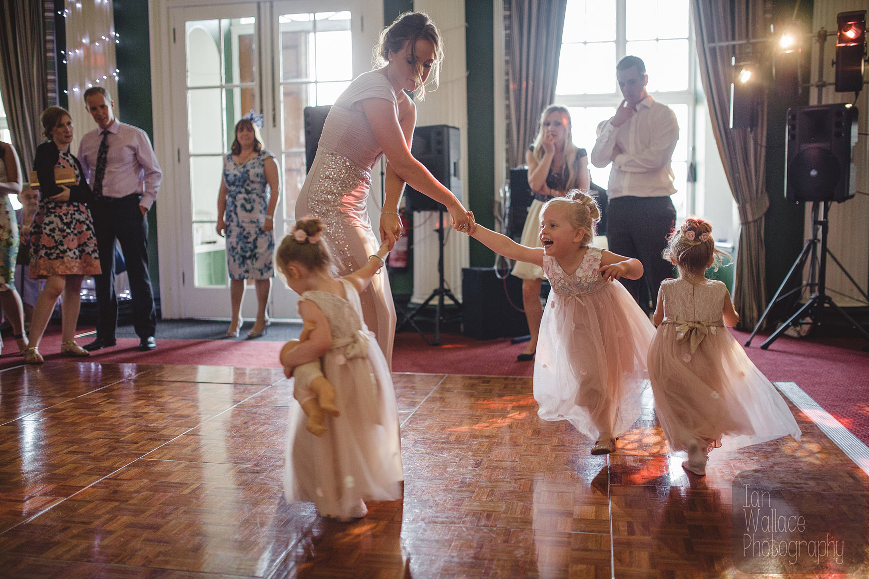 Bridesmaid dances/gets pulled around by the flower-girls at the disco.