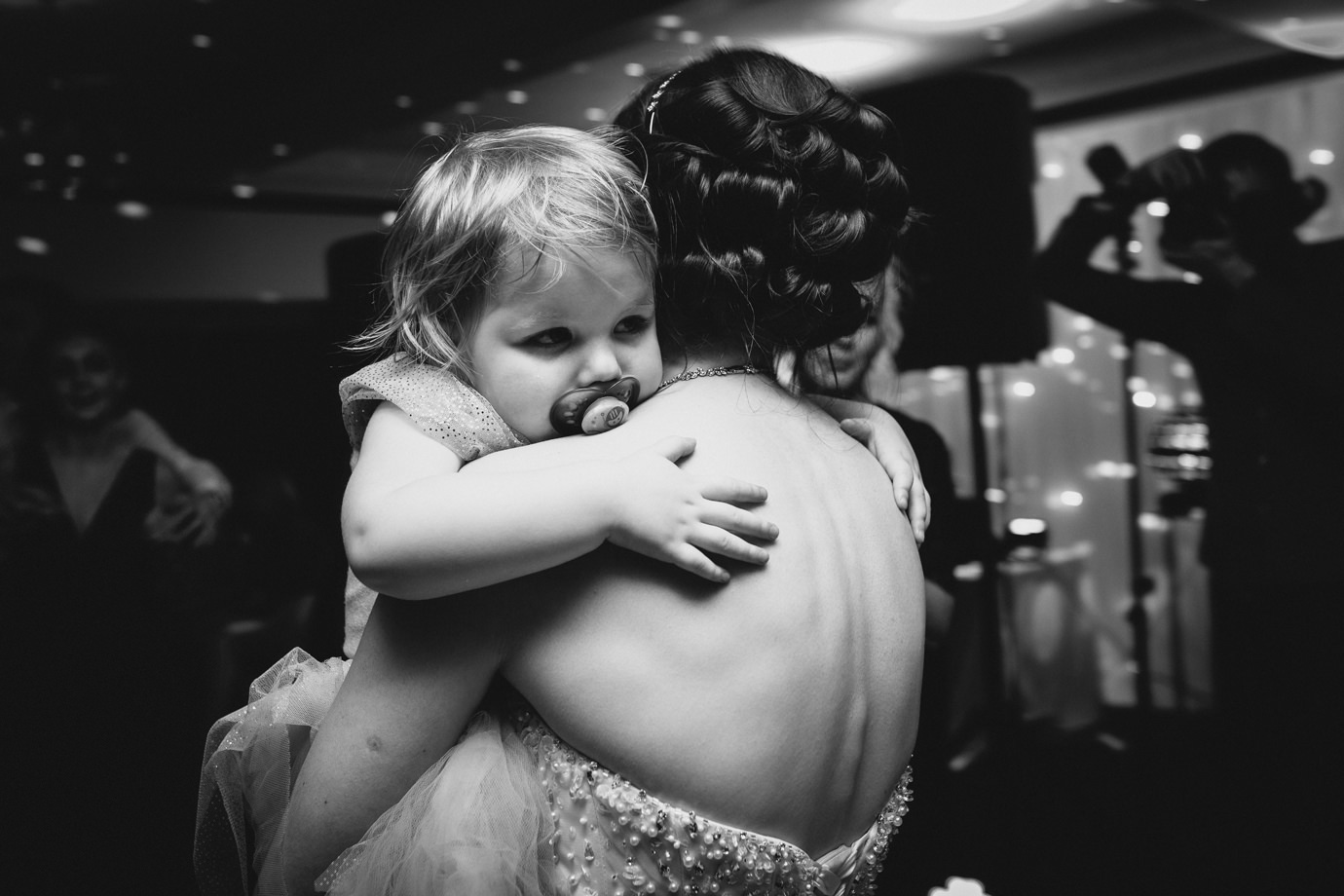 Child hugging the dancing bride. Documentary wedding photography